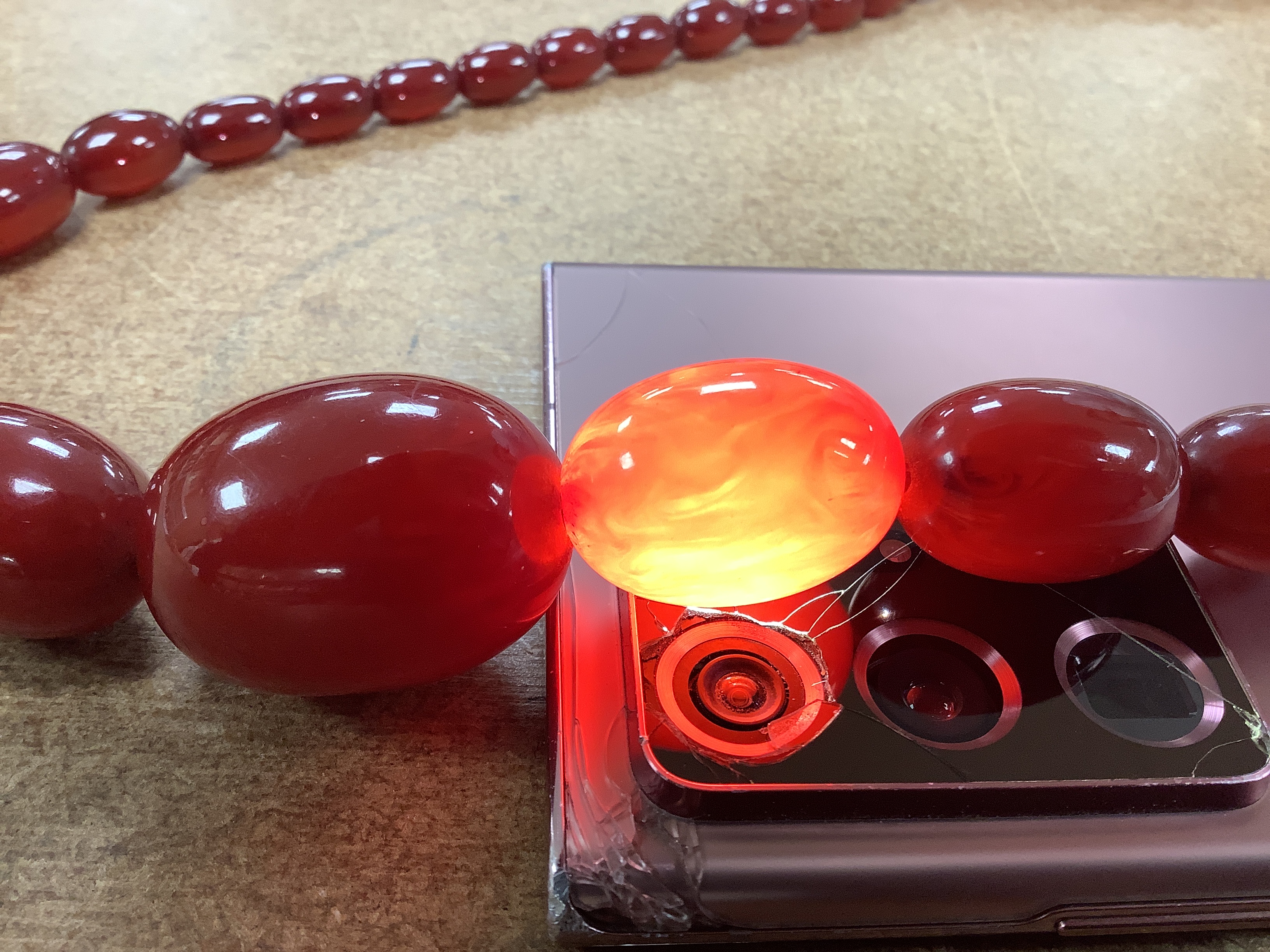 A single strand graduated oval simulated cherry amber bead necklace, 70cm, gross weight 63 grams.